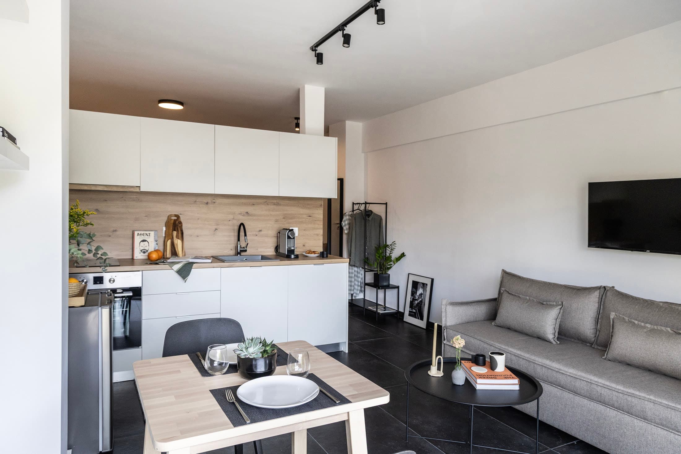 Modern open-plan studio with kitchen, dining table, and cozy living area.